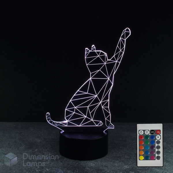 A 3D optical illusion lamp shaped like a sitting cat with a raised paw, emitting a white geometric light on a black base. A white remote control is shown to the right, and the brand name 'Dimension Lamps' in the lower-left corner against a dark background.