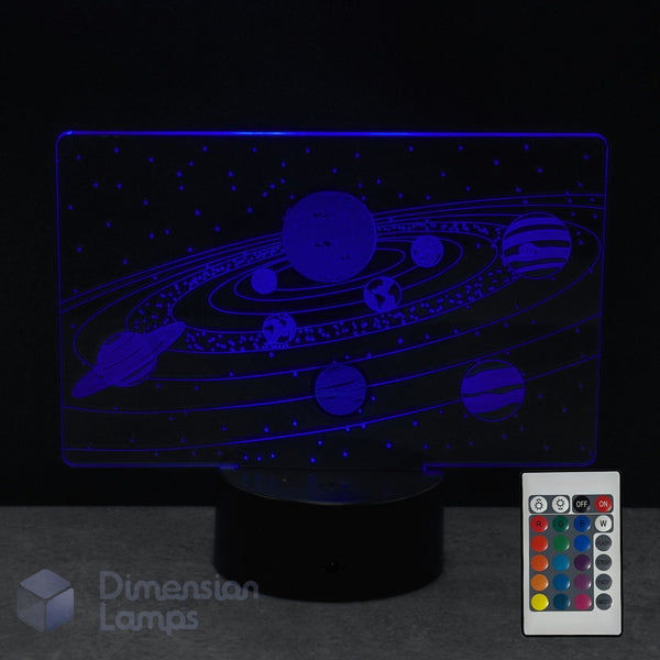 A Dimension Lamps solar system night light displaying planets and orbits, illuminated in blue-purple light. A 16 colour remote control in the corner.