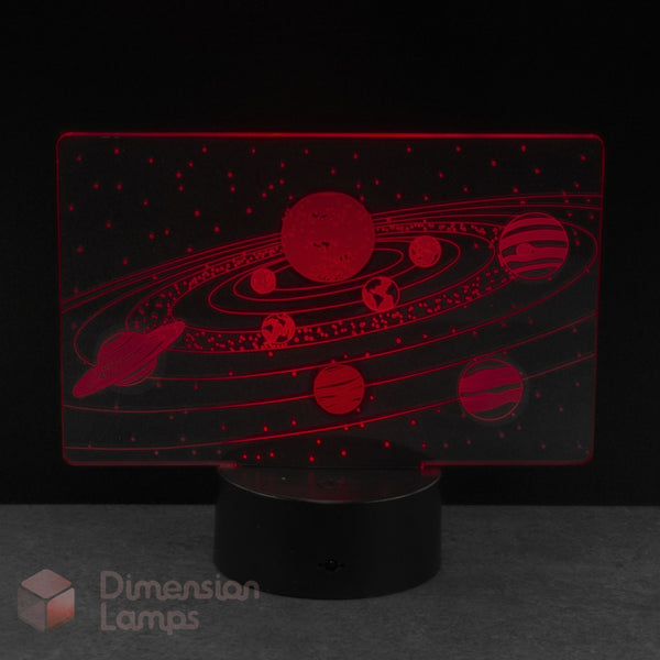 A Dimension Lamps LED night light featuring a red laser-cut solar system design on a clear acrylic panel. Young astronomers space themed gift idea. 