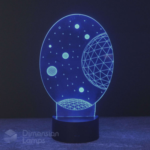 An oval-shaped 3D optical illusion night light by Dimension Lamps, displaying a glowing blue space design with planets and stars on a black base.