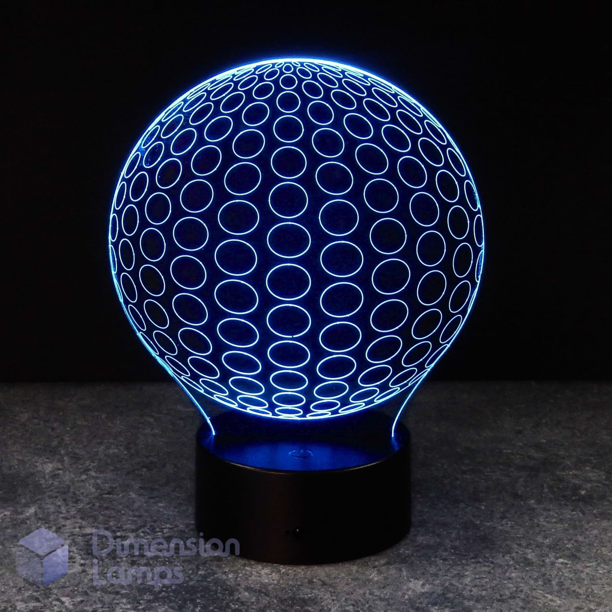 A 3D optical illusion LED lamp shaped like a sphere, glowing with a blue circular pattern on a black base against a dark background.