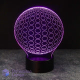 A 3D optical illusion LED lamp by Dimension Lamps, featuring a glowing purple sphere with concentric circle patterns on a black cylindrical base, set against a dark background.