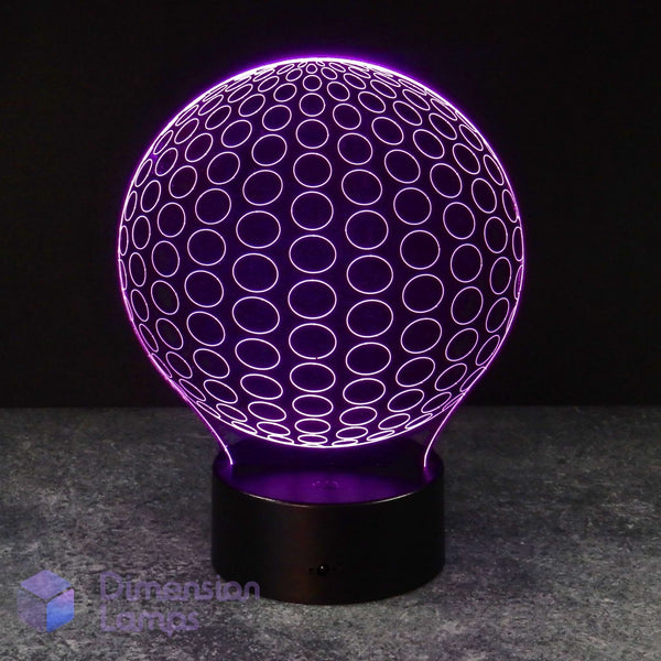 A 3D optical illusion LED lamp by Dimension Lamps, featuring a glowing purple sphere with concentric circle patterns on a black cylindrical base, set against a dark background.