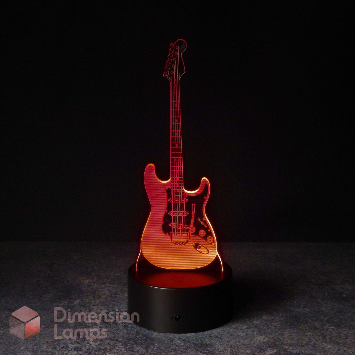 An electric guitar-shaped 3D LED night light glowing with red light, displayed on a black base against a dark background. A 'Dimension Lamps' watermark in the bottom-left corner. Gift for a guitarist.
