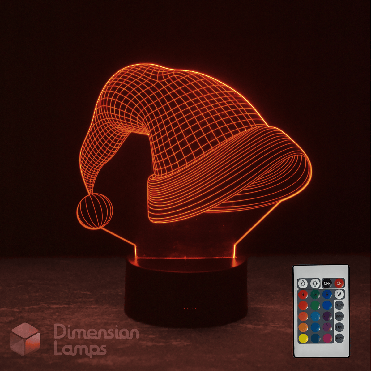 3D LED lamp shaped like a Santa hat with a remote control on a dark background. Fun Christmas lamp.