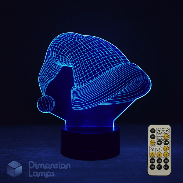 3D LED lamp shaped like a Santa hat with a remote control on a dark background. Christmas themed lamp.