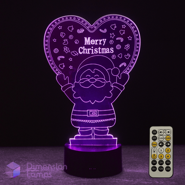 Heart-shaped LED lamp with Santa Claus design and 'Merry Christmas' text, accompanied by a remote control on a dark background.