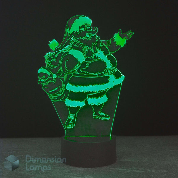 A 3D optical illusion LED night light depicting Santa Claus carrying a sack of gifts, glowing bright green against a dark background on a black cylindrical base.