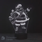 A 3D acrylic LED night light featuring a humorous, jolly Santa Claus character holding a skull sack, glowing white against a dark black background on a black base.