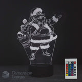 A 3D optical illusion LED night light depicting a cartoon Santa Claus carrying a sack, shown on a black base with a 16 colour remote control in the corner. The brand 'Dimension Lamps' is visible as a watermark.
