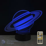 A Saturn 3D optical illusion lamp glowing with blue light, 7-colour remote control on a dark surface against a black background. Kids space lamp.