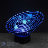 An oval-shaped 3D LED night light depicting a solar system with glowing blue planets and stars on a black base, set against a dark background. Kids space gift. 