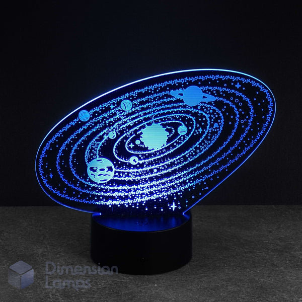 An oval-shaped 3D LED night light depicting a solar system with glowing blue planets and stars on a black base, set against a dark background. Kids space gift. 