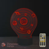 A 3D optical illusion night light shaped like the solar system, glowing with red light on a black base, shown with its white remote control against a dark background. A 'Dimension Lamps' logo is visible in the bottom-left corner.