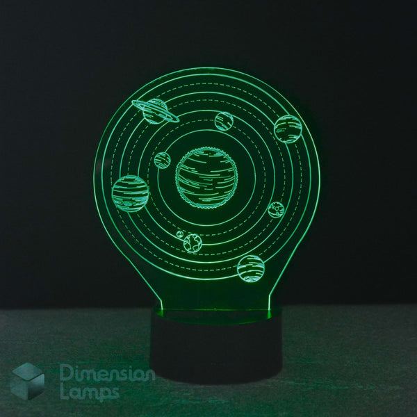 A 3D optical illusion night light featuring a glowing green solar system design with planets and rings on a black base. The brand name 'Dimension Lamps' is visible as a watermark in the bottom-left corner.