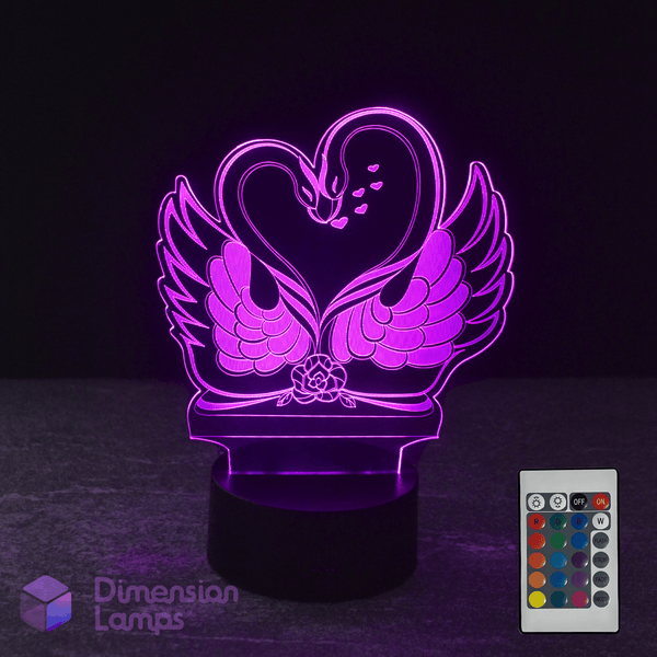 3D LED lamp shaped like a swan with a heart, accompanied by a remote control on a dark background.