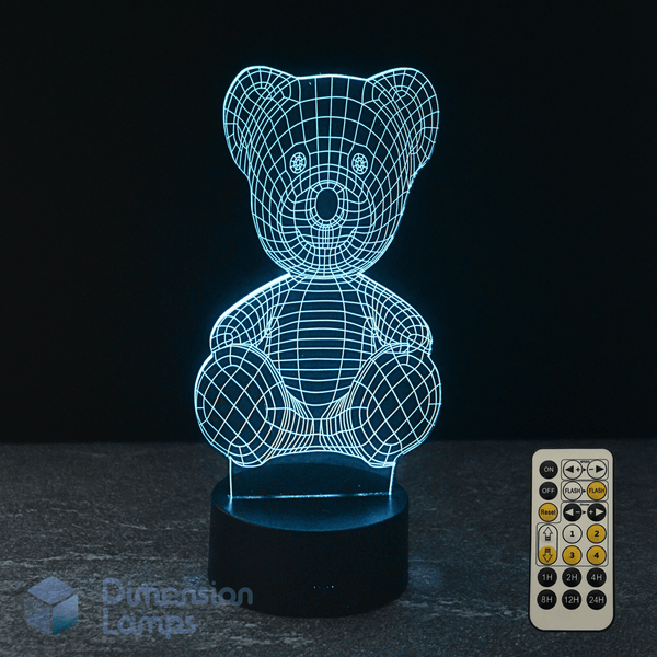 3D wireframe kids night light teddy bear lamp with remote control on a dark surface.