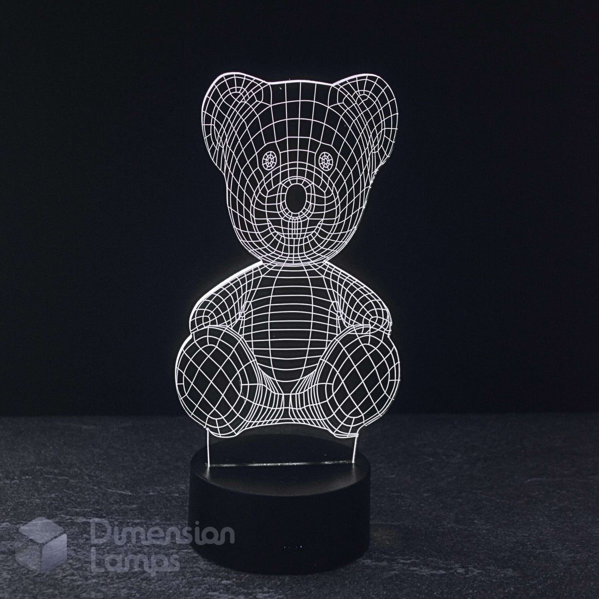 A 3D optical illusion LED night light of a teddy bear, featuring a glowing white wireframe design on a black base, set against a dark background.