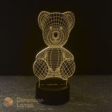A teddy bear 3D optical illusion LED night light on a black base against a dark background. warm golden light, gift idea for kids that love teddies.