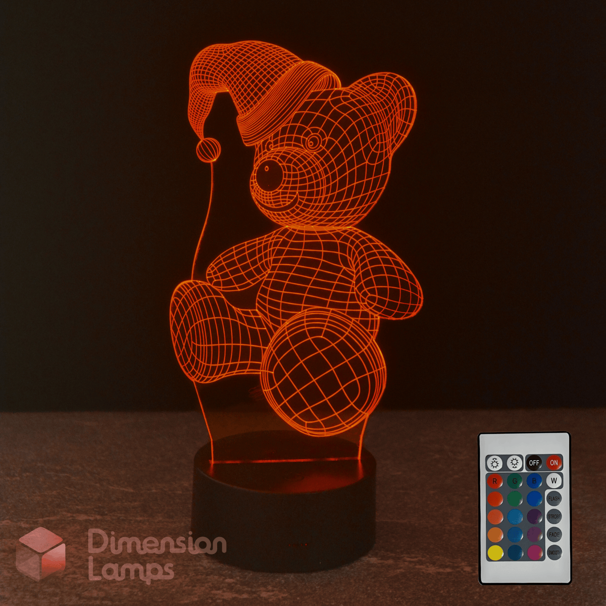 3D LED lamp shaped like a teddy bear with a remote control on a dark background. Christmas kids gift idea.