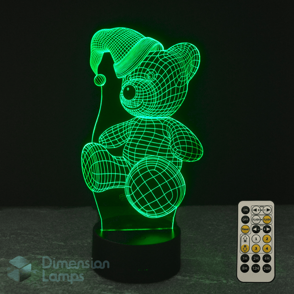 3D LED lamp shaped like a teddy bear with a remote control on a dark background. Kids Christmas night light.