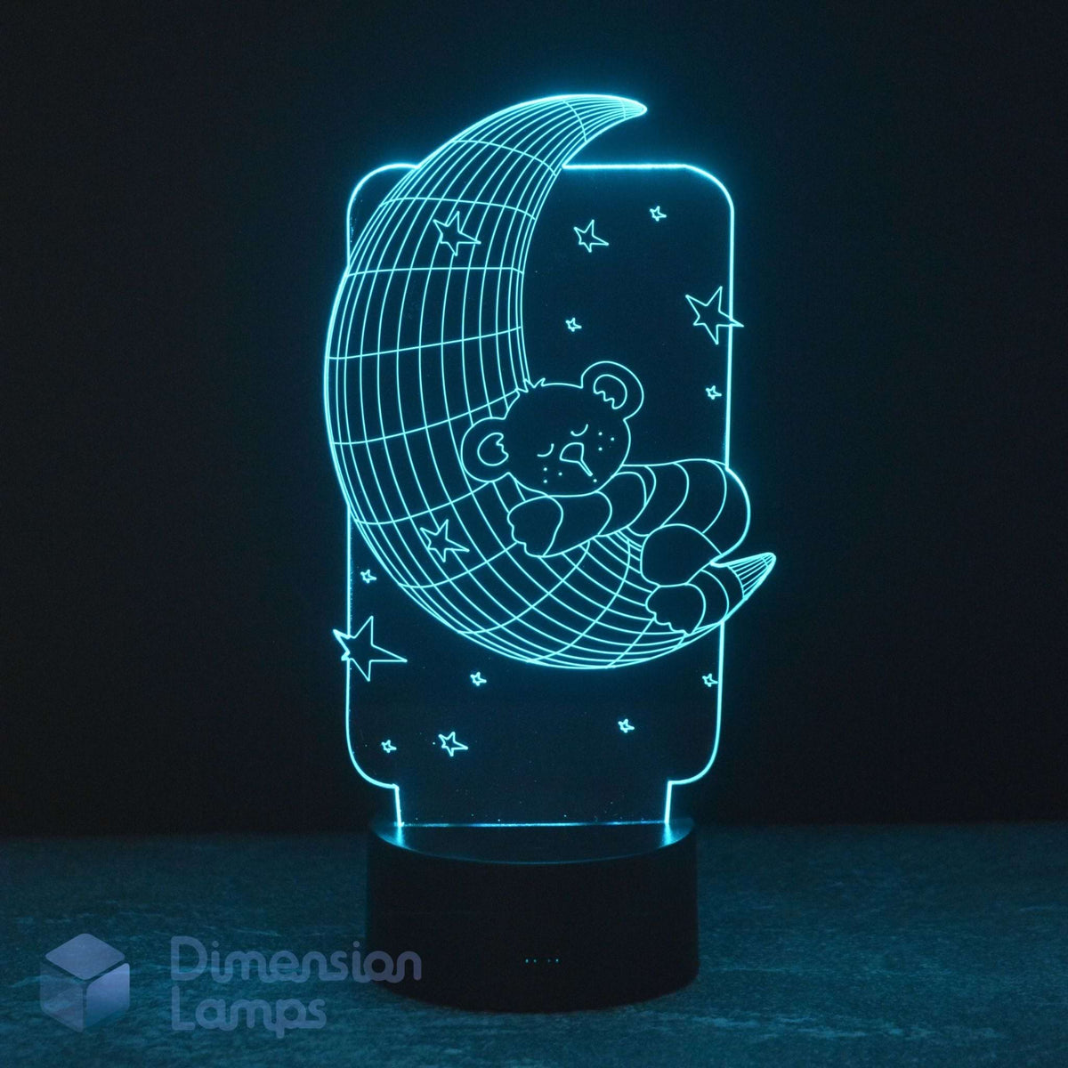 A 3D illusion LED night light by Dimension Lamps, featuring a glowing teddy bear sleeping on a crescent moon with stars against a dark background.