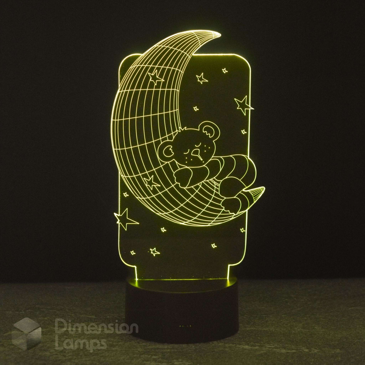 A 3D lamp by Dimension Lamps featuring a teddy bear sleeping on a crescent moon under stars, glowing warm yellow light against a dark background.