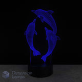 3D dolphin lamp with blue light on a black background. Marine life gift idea.