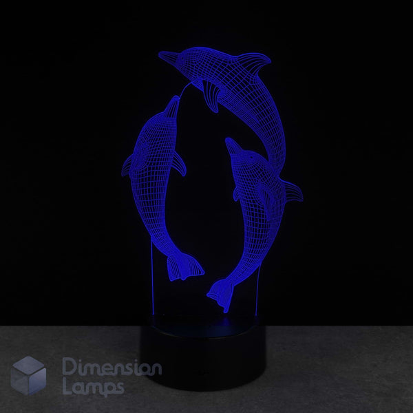 3D dolphin lamp with blue light on a black background. Marine life gift idea.