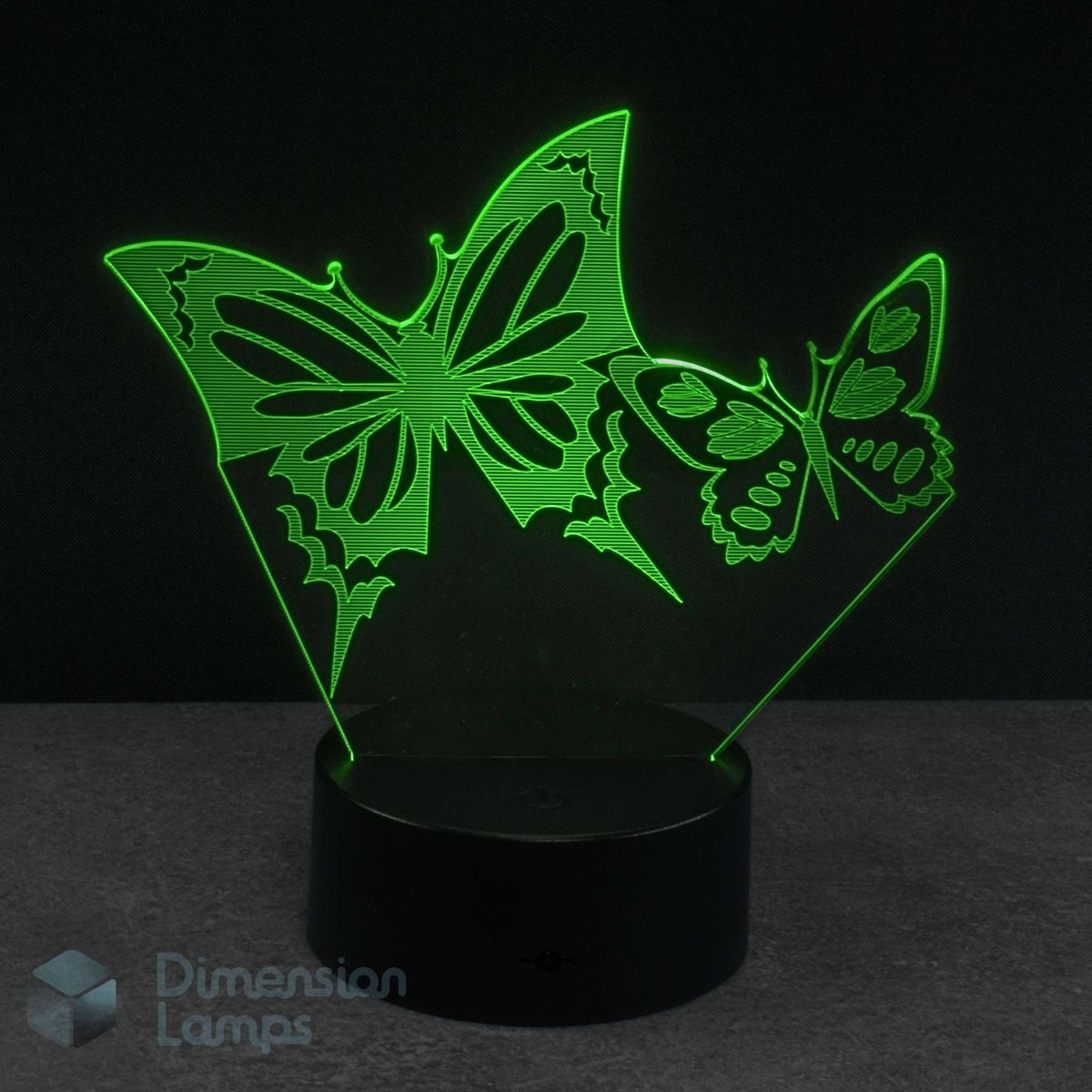 A 3D optical illusion night light featuring two glowing green butterfly shapes on a black base.