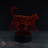 A 3D optical illusion LED night light shaped like a walking cat, glowing with a red light from a black cylindrical base on a dark grey surface against a black background. Cat lovers gift idea.