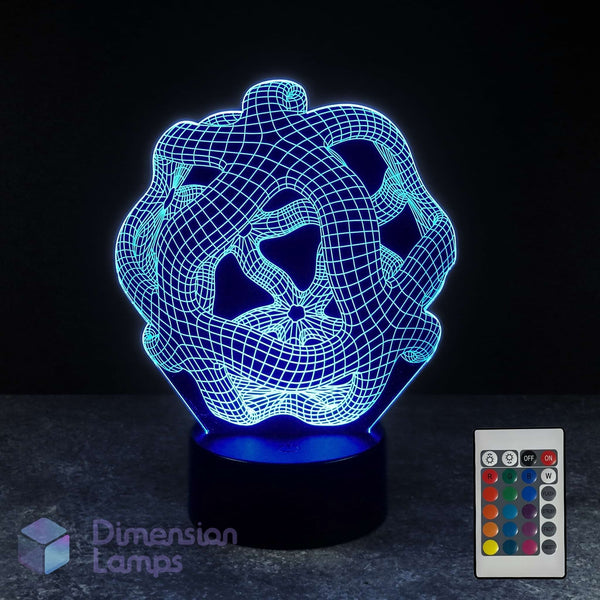 A 3D optical illusion lamp with a cyan wireframe warped space design on a black base, shown alongside its 16 colour remote control against a dark background.