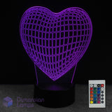 Wireframe heart-shaped 3D LED lamp with grid pattern and remote control on a dark background. Girls night light gift idea. 