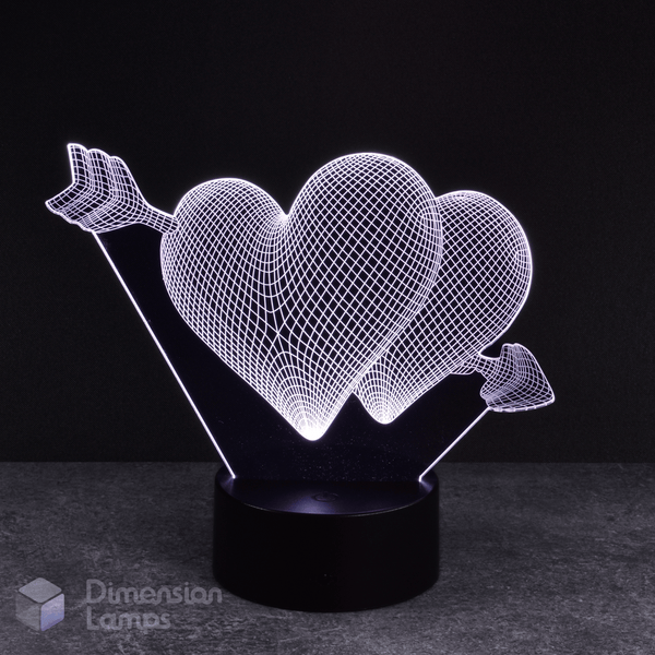 White hearts and arrow 3d night lamps: a love-themed design featuring two hearts pierced by an arrow, illuminated by white LEDs on a base against a dark background. A unique lighting solution for a girl's room. 