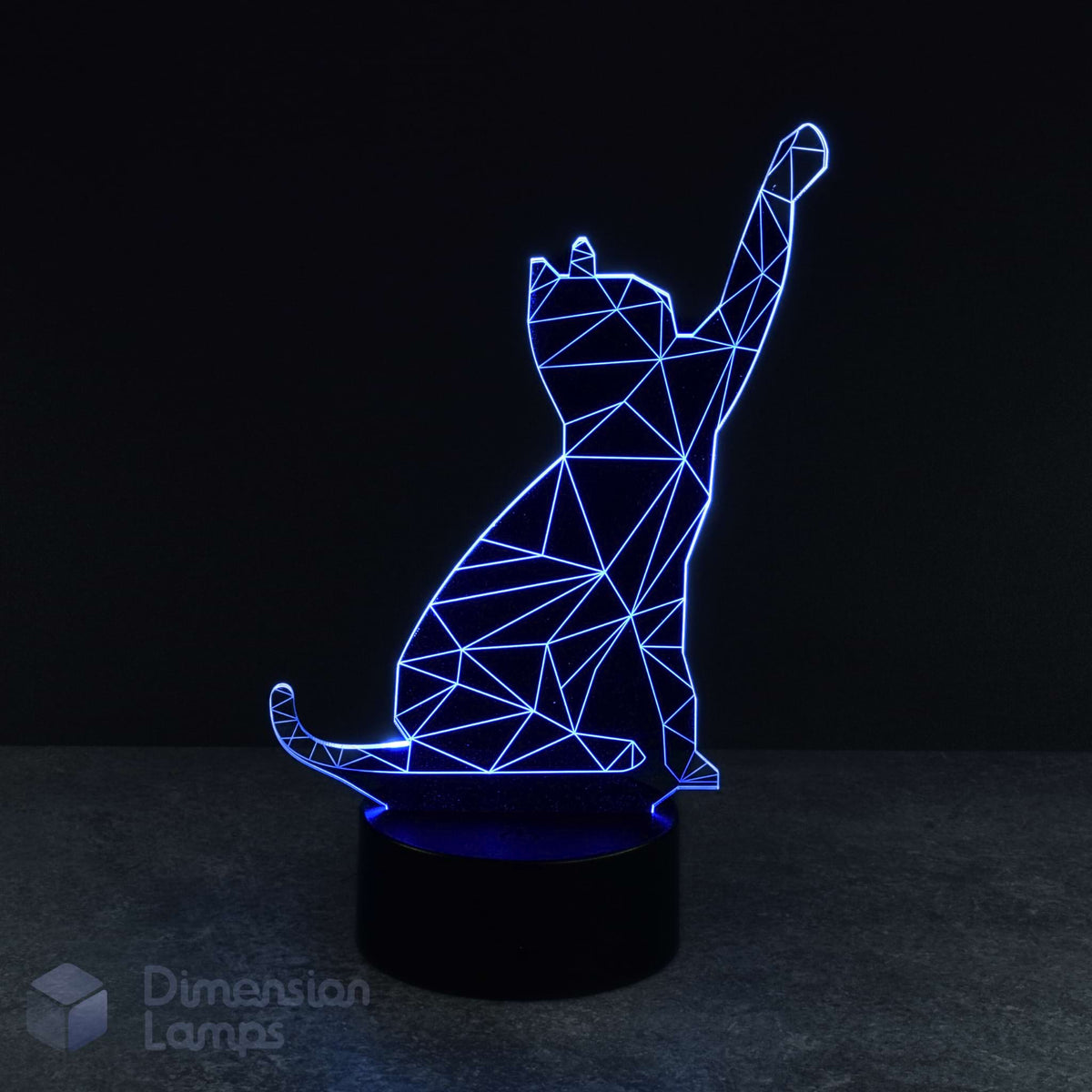 A 3D lamp with a black base emits a blue glow, highlighting the geometric wireframe design of a cat playfully reaching upwards. A cool nightlight for cat fans and pet admirers. 