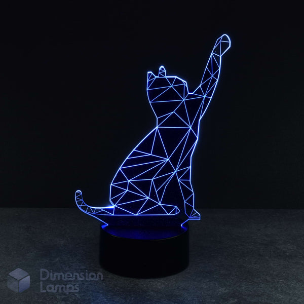 A 3D lamp with a black base emits a blue glow, highlighting the geometric wireframe design of a cat playfully reaching upwards. A cool nightlight for cat fans and pet admirers. 