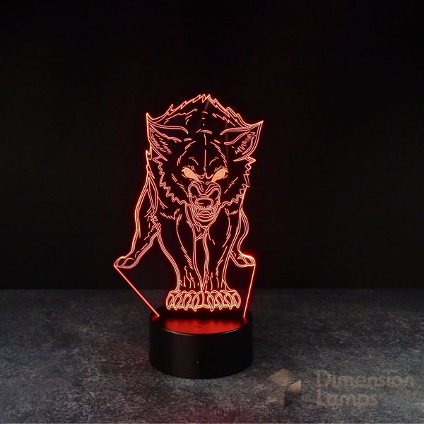 A 3D illusion lamp of a detailed wolf, its form defined by red faceted planes, showcasing glowing eyes and bared teeth, standing on a textured base against a dark background. A cool gift for teens.