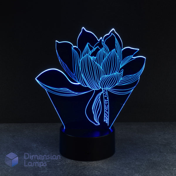 Blue lotus flower 3d night lamps: a decorative lamp featuring the intricate design of a blue illuminated lotus blossom on a circular black base against a dark backdrop. This floral-inspired piece provides a calming ambient light for any home. 