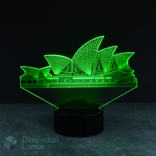 A 3D illusion lamp presents a detailed silhouette of the Sydney Opera House, a renowned Australian landmark, illuminated in green, emanating upwards from a black base against a dark background. A distinctive and engaging piece of Australiana. 