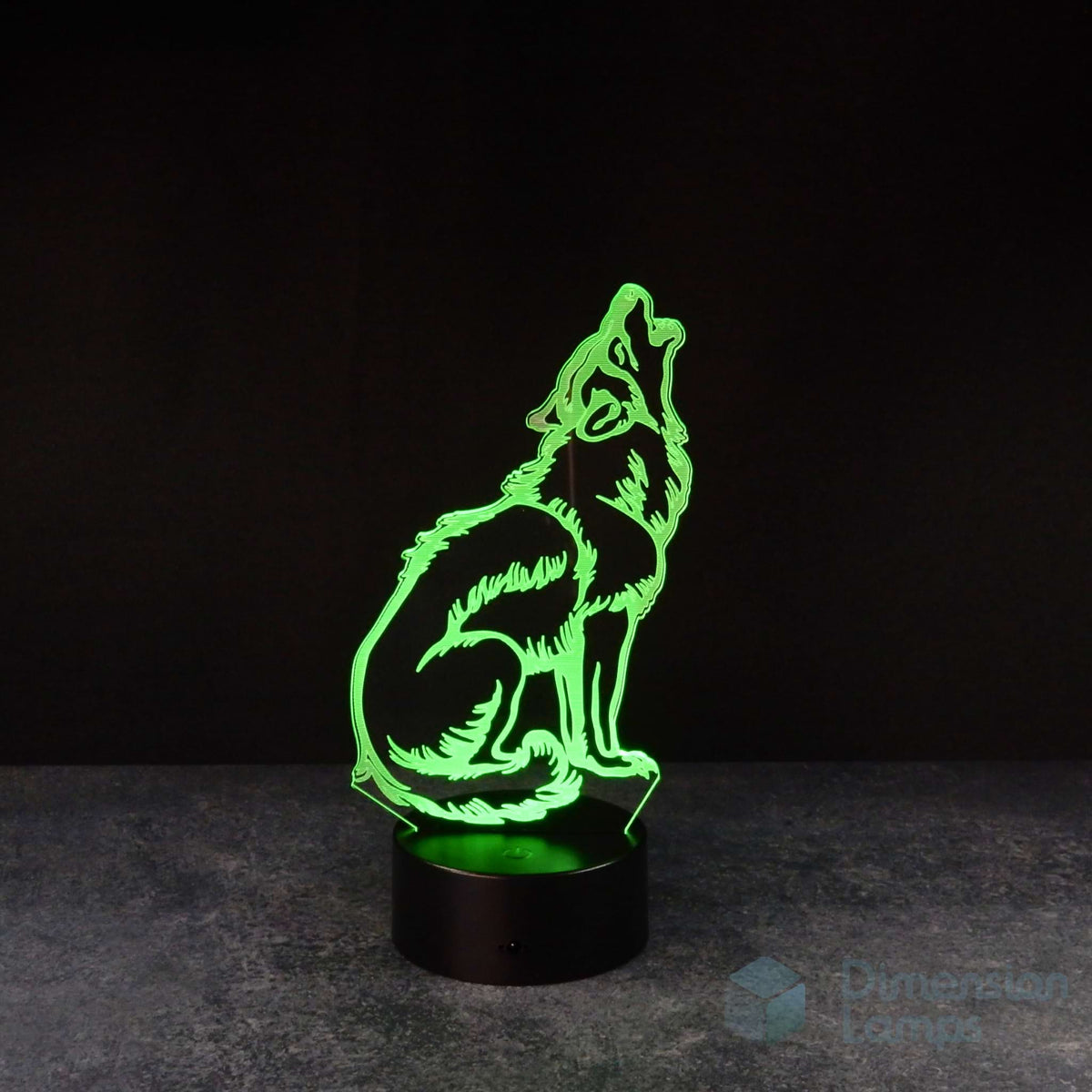 A 3D illusion lamp of a howling wolf, its form defined by green faceted planes, with its head raised and mouth open, on a black base against a dark background. An animal-themed night light. 
