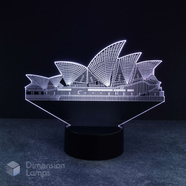 Sydney Opera House 3d night lamps: white illumination of the detailed architectural form of this iconic Australian landmark on a lamp, rising from a black base against a dark background. A thoughtful Australiana gift idea.