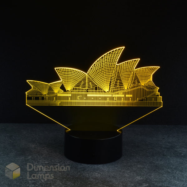 A yellow illuminated 3D lamp depicts the iconic Sydney Opera House, standing on a black base against a dark background. A recognisable landmark and piece of Australiana, perfect for homes across Australia.
