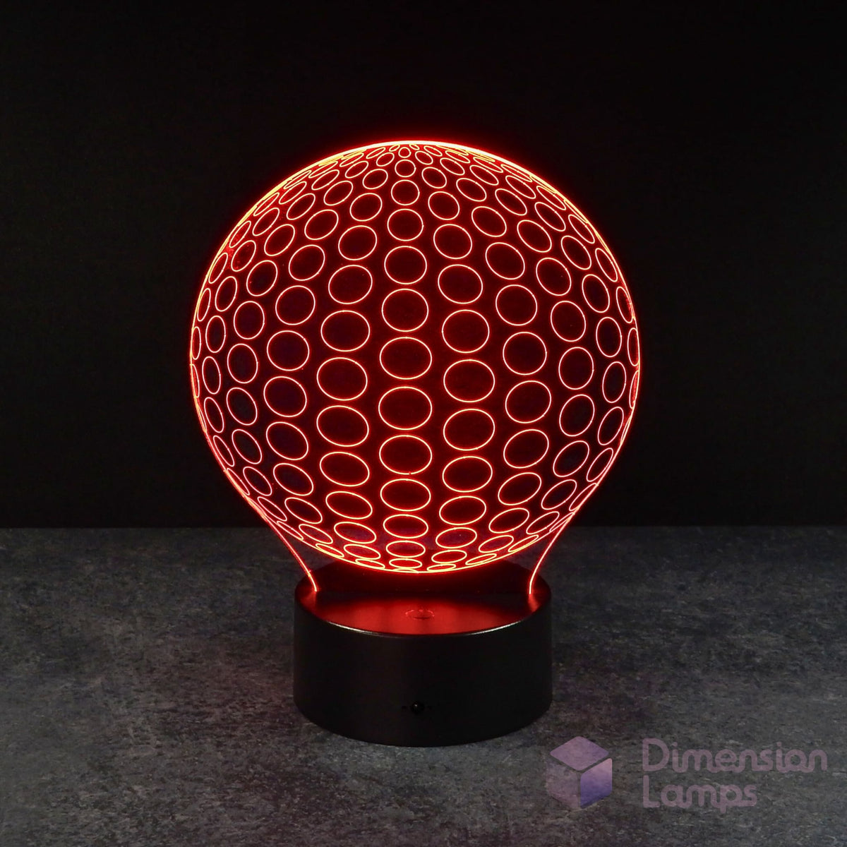 A 3D illusion lamp presenting a symmetrical pattern of radiating circles forming a sphere, illuminated in red, resting on a black base against a dark background. Its symmetry makes for a great study aid.