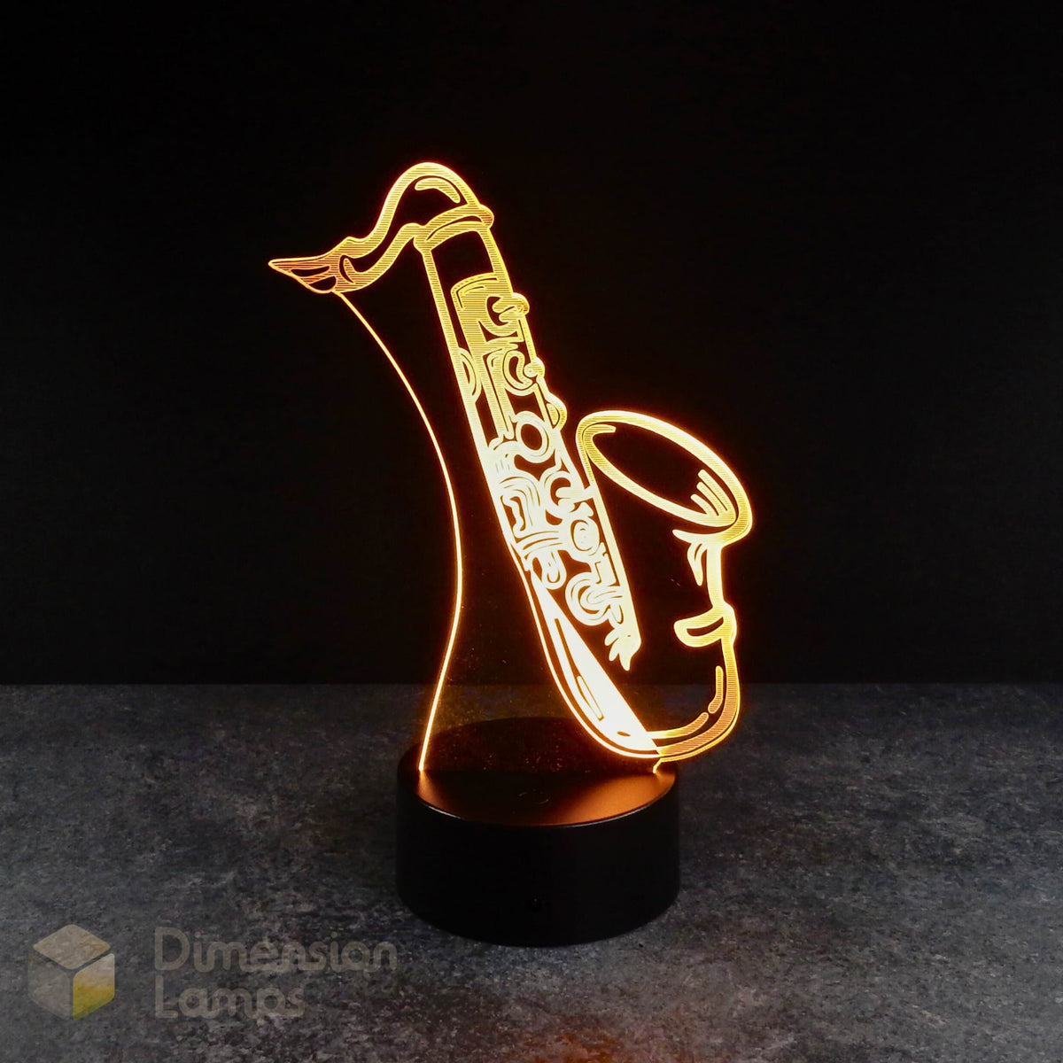 3D LED illusion lamp in the shape of a saxophone, illuminated with a warm light, placed on a black surface. Saxophone fan gift idea.